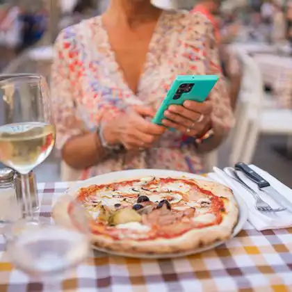 Mulher provando pizza, uma das comidas típicas da Itália