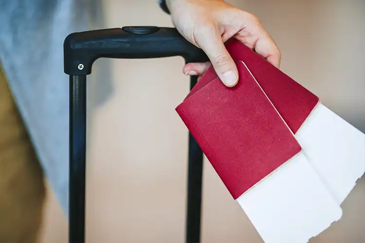 Homem segurando dois passaportes 