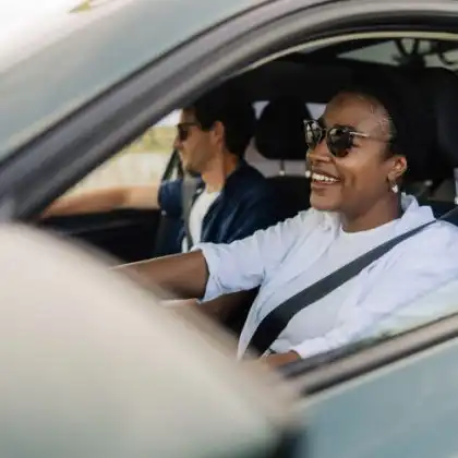 Mulher e homem brasileiros andando de carro na Europa