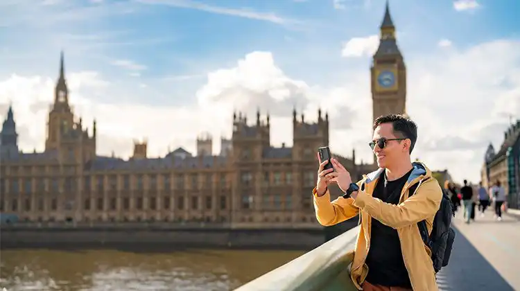 Homem com celular na frente do Big Ben