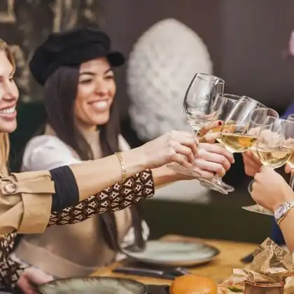 Grupo de amigos brinda com vinho no restaurante