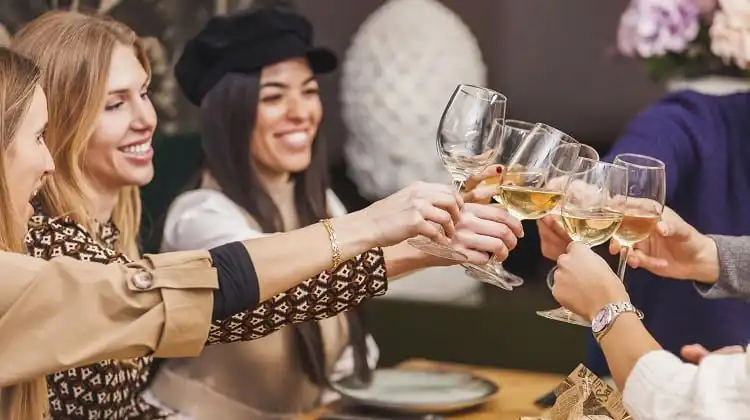 Grupo de amigos brinda com vinho no restaurante
