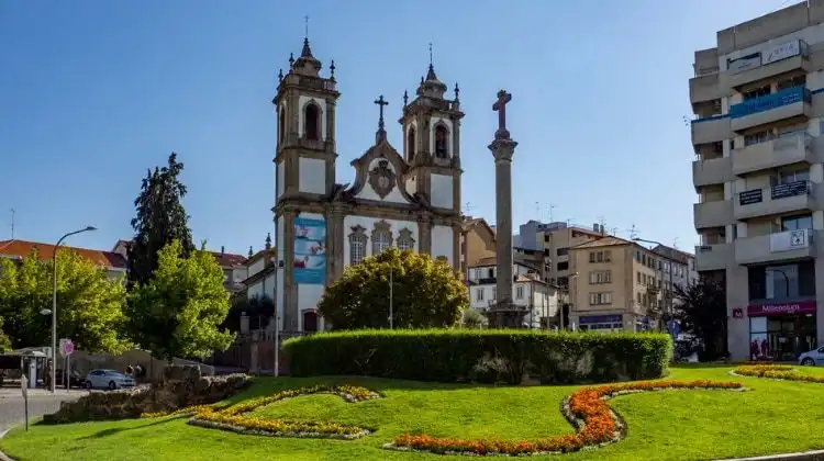 Praça em Viseu com igreja e céu azul