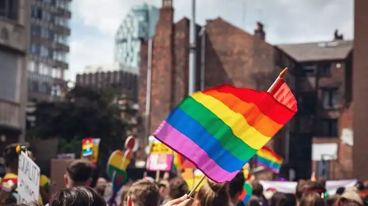 Bandeira LGBTQIA+ erguida em parada na Europa.