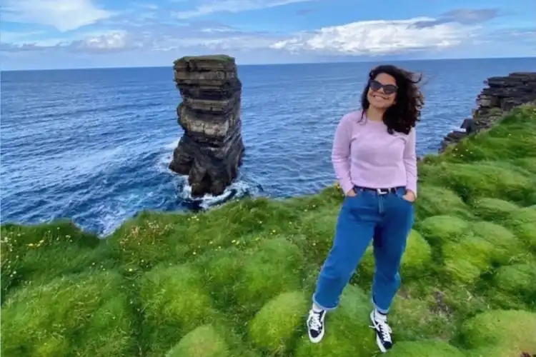 Mulher no Cliffs of Moher, na Irlanda
