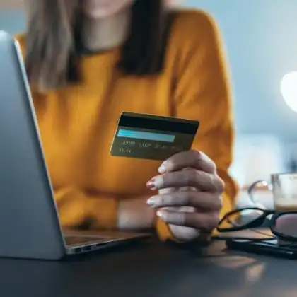 Mulher com cartão de crédito e computador