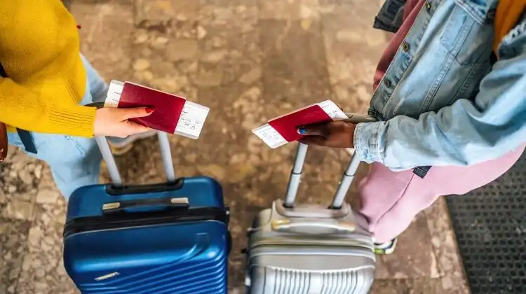 Mulheres com bagagem e passaporte na mão