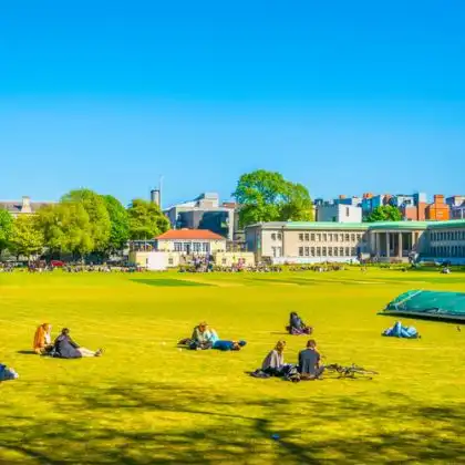 Estudantes deitados no gramado de uma universidade na Irlanda