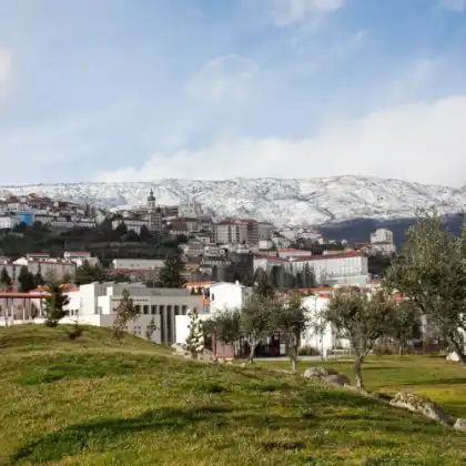 Covilhã, em Portugal com as serra coberta por neve ao fundo.