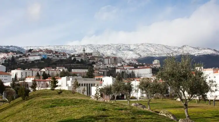 Covilhã, em Portugal com as serra coberta por neve ao fundo.