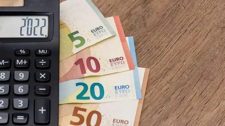 Notas de euro embaixo de uma calculadora.