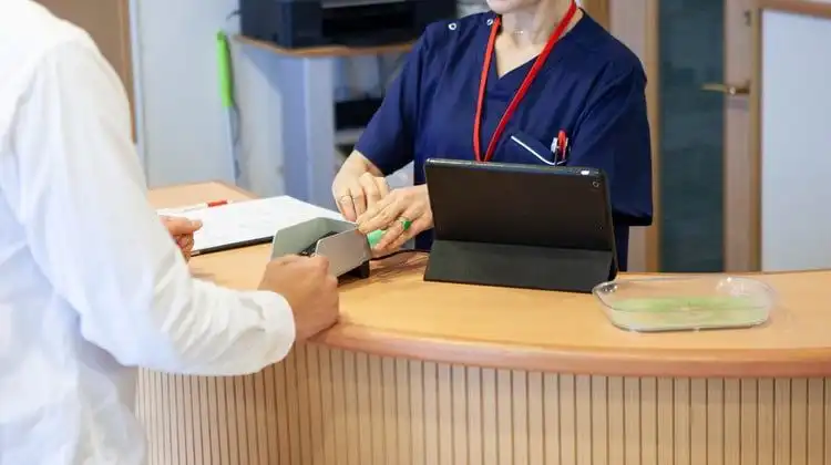 Secretária de posto de saúde emite a tarjeta sanitaria na Espanha no balcão de atendimento