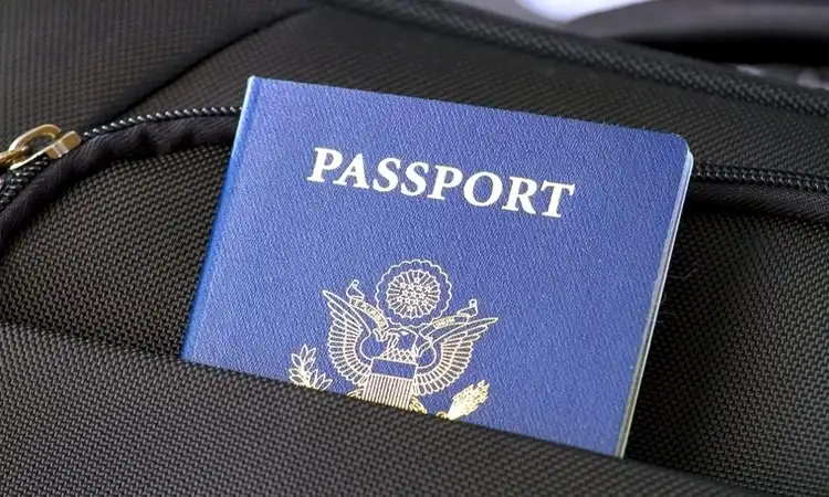 Passaporte colocado no bolso de uma mala preta