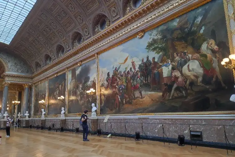Pessoa olhando um grande quadro em um museu parisiense.