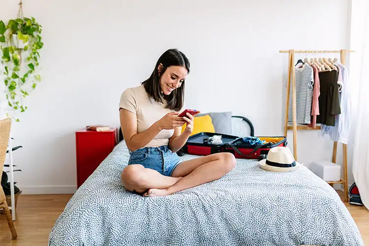 Imigrante morando sozinha na Europa, em seu quarto, com as malas