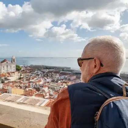 Senhor aposentado observando Lisboa de um local alto.