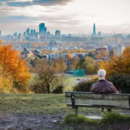 Homem aposentado na Inglaterra olhando a vista da cidade