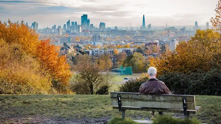Homem aposentado na Inglaterra olhando a vista da cidade