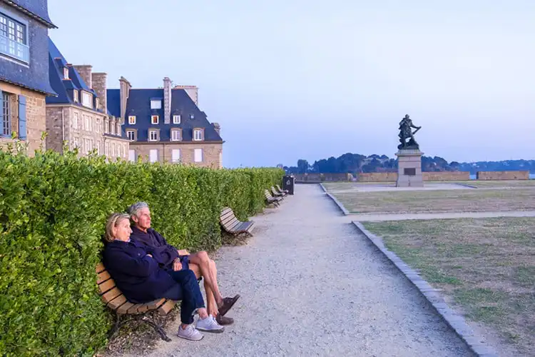 Casal sentado em banco de praça em cidade da França