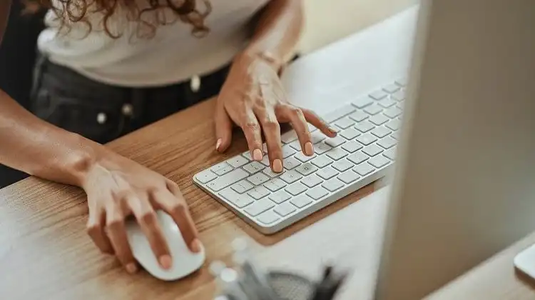 Mulher em computador, fazendo apostilamento eletrônico.