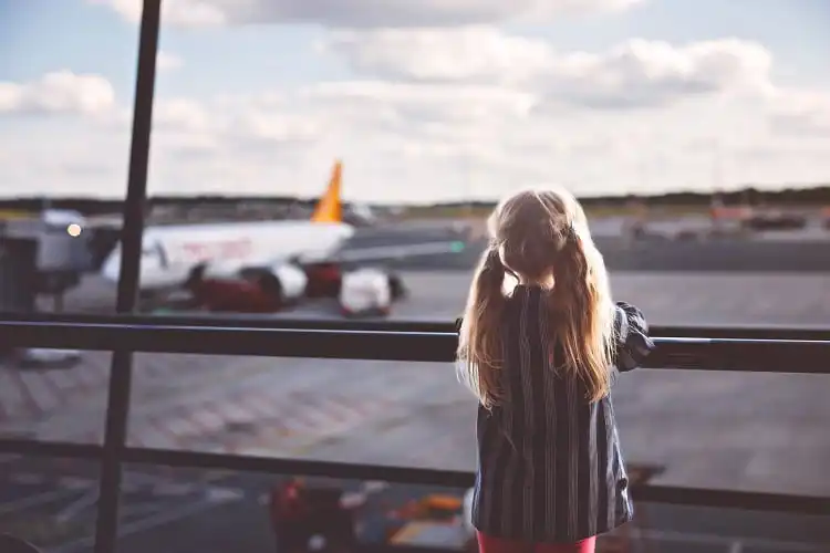 Criança em janela de aeroporto.