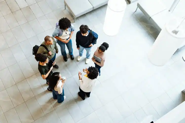 Fotografia de cima para baixo de um grupo de estudantes e professores reunidos