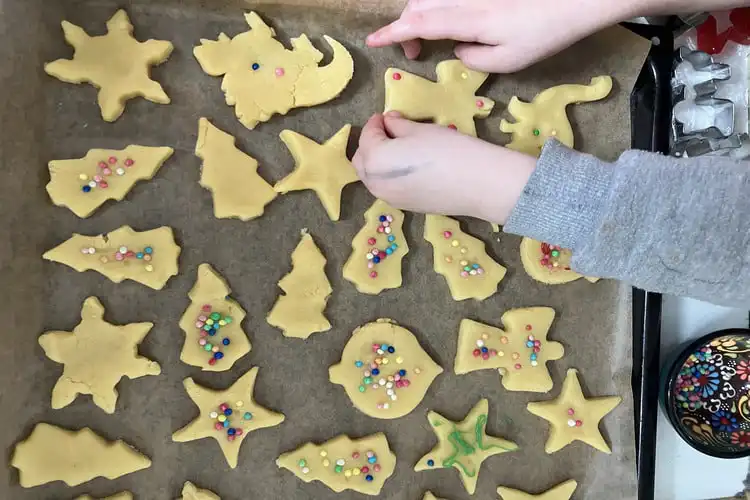 mãos de criança decoram biscoitos de natal
