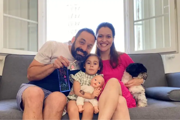 Família de brasileiros sorrindo no sofá comemorando dia dos pais na França