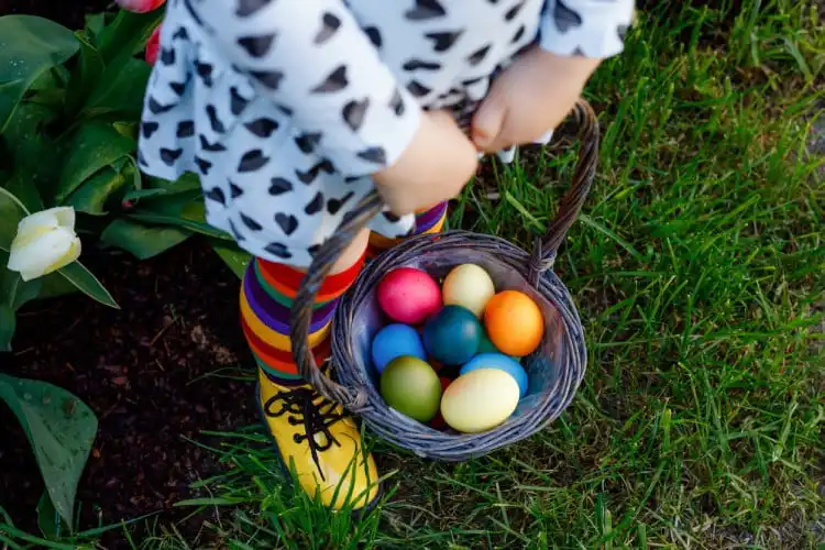 Criança segurando cesta de ovos de Páscoa