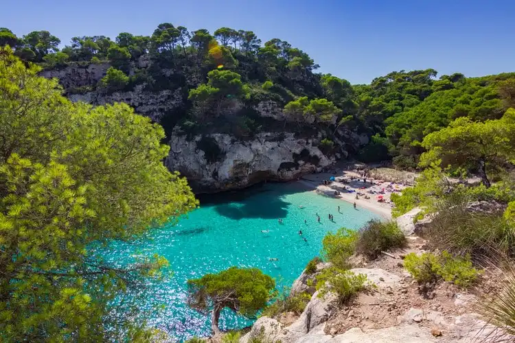 Cala entre pedras na ilha de Menorca, nas Baleares, que são um dos destinos de verão mais bonitos para viajar para Espanha