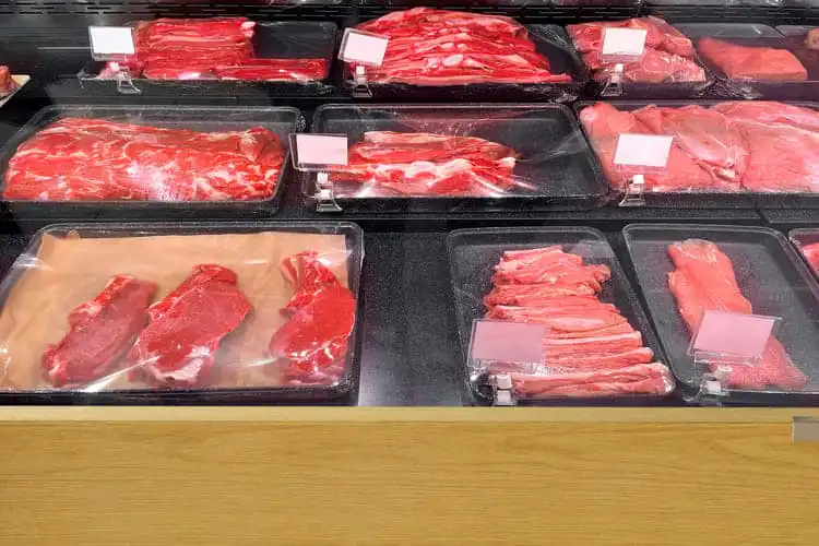 Carnes já cortadas e embaladas em um freezer.