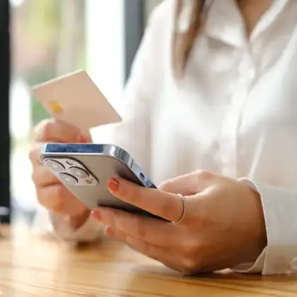 Mulher pagando contas pelo cartão de débito internacional online.