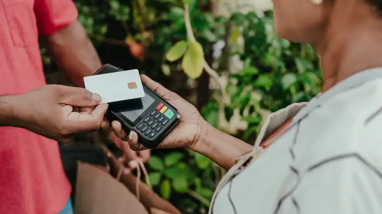 Mulher pagando conta com cartão de débito no exterior