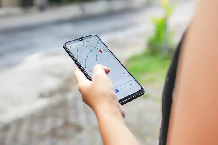 Pessoa segurando celular com aplicativo de mapa aberto
