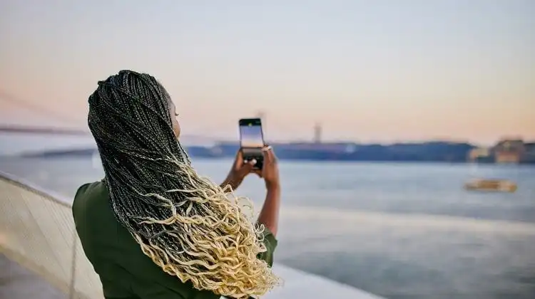 Mulher tirando foto durante viagem, usando chip de internet na Europa