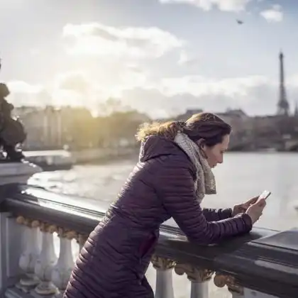 Mulher usando celular no exterior