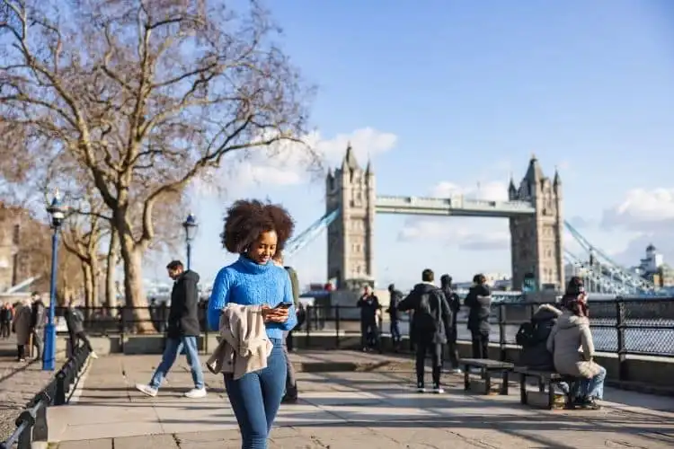 Moradora de Londres usando o celular enquanto caminha pela cidade.