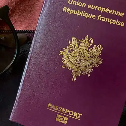 o passaporte francês ao lado de óculos escuros