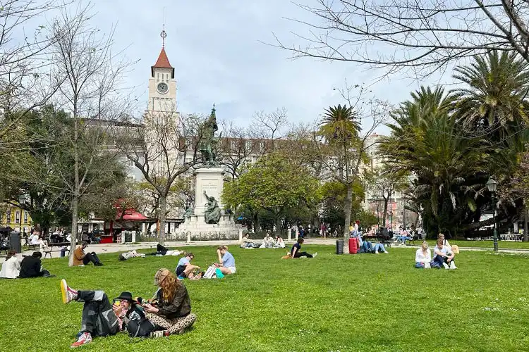 Pessoas descansam em uma praça na capital portuguesa.