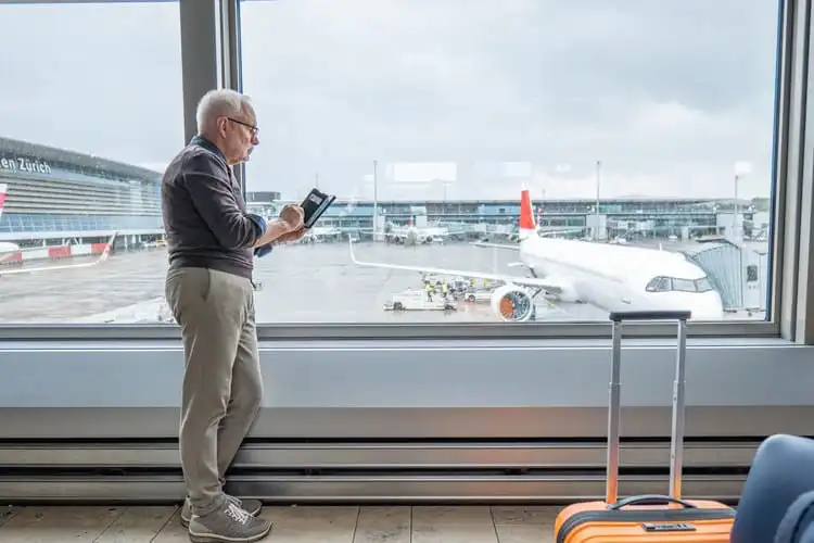 Homem com mais de 85 anos acionando seguro viagem no aeroporto.