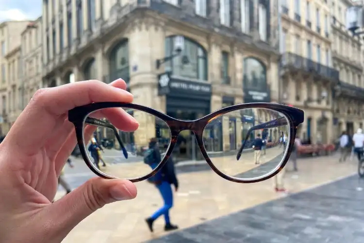 Mão segurando óculos de grau na França