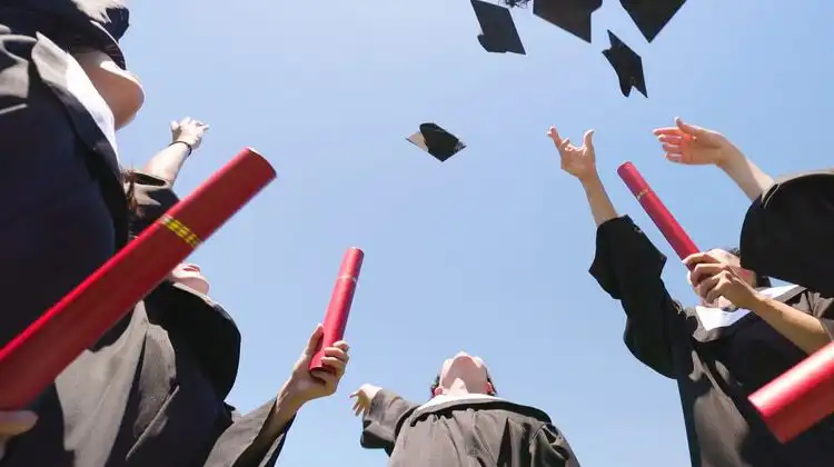 Estudantes que acabam de se formar na Espanha com os diplomas nas mãos