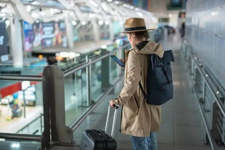 Mulher no aeroporto usando seu chip internet na Inglaterra.