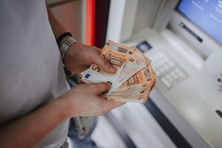 Homem segurando notas de euro e se perguntando como comprar euros mais barato