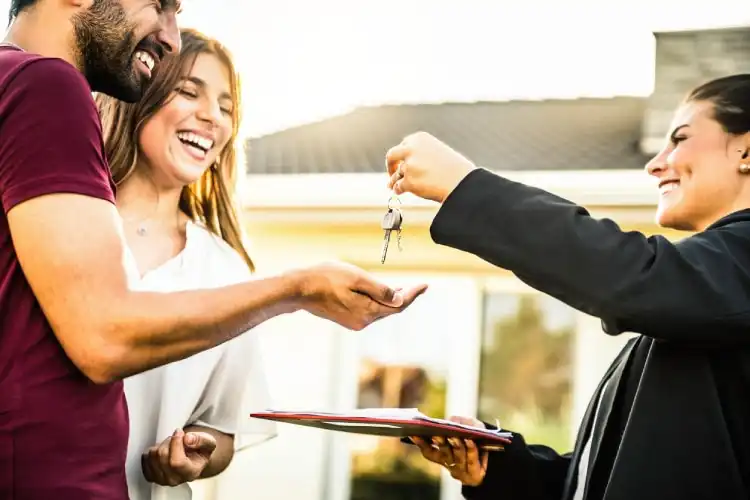 Consultora imobiliária passa as chaves de casa para um casal