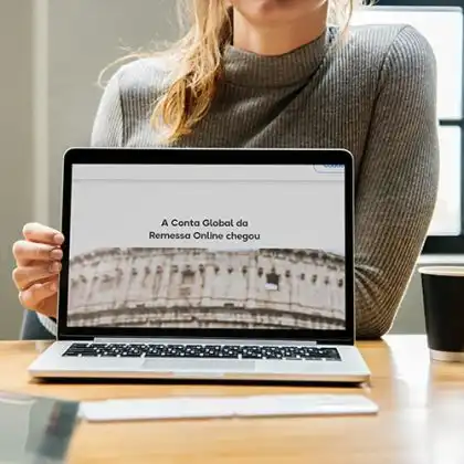 Mulher apresentando a Conta Global Remessa Online no computador