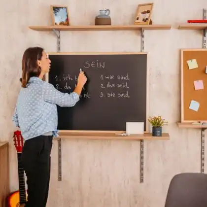 Professora escrevendo em alemão em lousa de giz