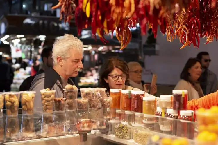 Casal escolhe temperos e condimentos no mercado municipal de Barcelona