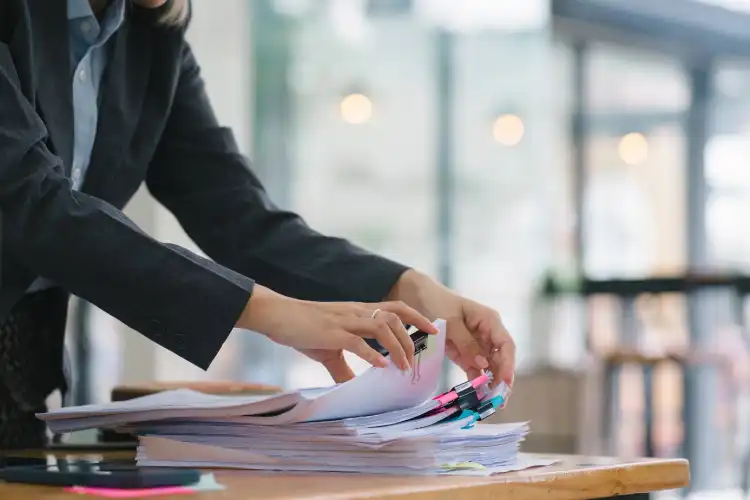 Mulher organizando pilha de documentos