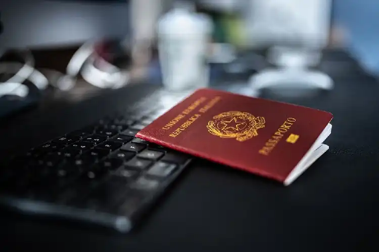 Passaporte italiano em frente ao computador